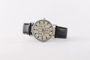 Detail view of quartz watch with beige dial, silver case, and black croc leather strap