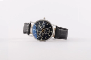 Detail of silver quartz watch with black leather strap and three chronograph sub-dials