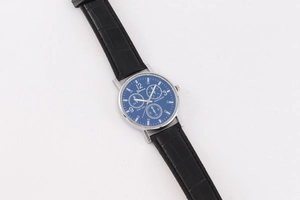 Detailed close-up of a Geneva men's watch with blue dial and black leather strap
