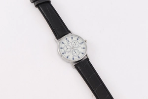 Top view of Geneva quartz watch with white dial, silver case, and black leather strap
