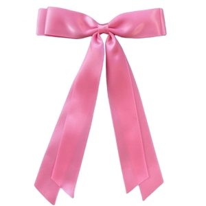 Detail of pink satin bow hair clip with long ribbons on a clean white background
