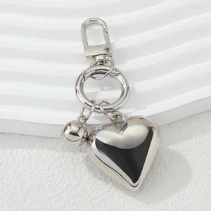 Sleek silver hollow heart pendant keychain with bell and D-ring on minimalist white background