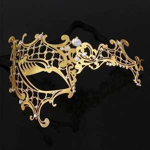 Detailed view of golden filigree metal masquerade mask with sparkling rhinestones decoration