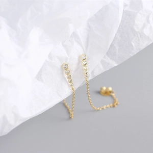 Macro shot of gold long chain tassel earrings featuring elegant vertical diamond settings