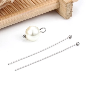 Close-up of silver-tone steel ball pins and white imitation pearl for DIY jewelry making