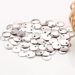 Close-up of bulk silver round stainless steel blank tags with pre-drilled holes