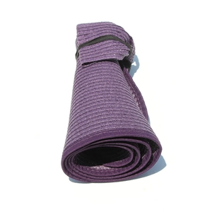 Detail of purple straw sun hat in rolled-up compact state with elastic storage strap