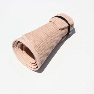 Foldable pink straw sun visor showing portable roll-up design and woven texture