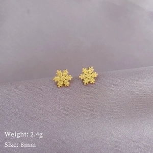 Matte gold snowflake stud earrings on purple satin fabric with 8mm size specification