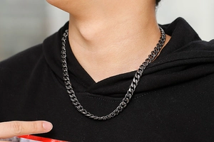 Close-up of vintage Cuban link chain necklace in dark stainless steel on a model