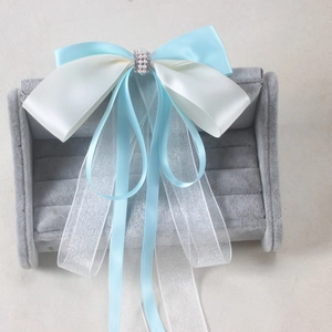 Elegant blue and white bow hair clip with flowing ribbons and pearl accents for women