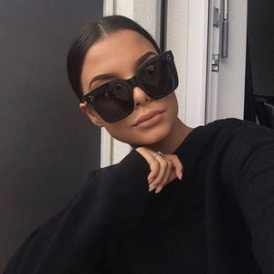 Nahaufnahme: Model mit schwarzer quadratischer Sonnenbrille und drei Metallnieten