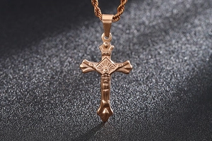 Macro shot of rose gold stainless steel crucifix pendant with detailed Jesus figure