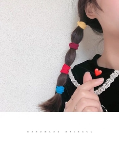 Detail of colorful elastic nylon hair bands shown on a side-braid hairstyle