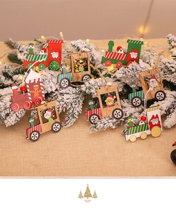Detailed view of wooden Christmas train ornaments with Santa and deer hanging on pine branches