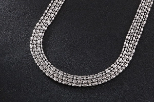 Macro shot of multi-layer silver stainless steel bead chains with polished metal texture