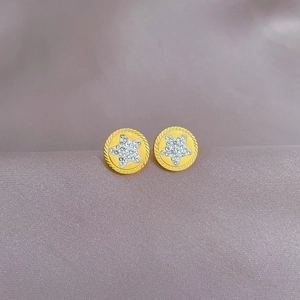 Minimalist gold star stud earrings with white zircons on purple satin background