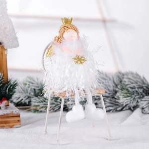 White Christmas angel doll with gold crown sitting on a white iron chair decor