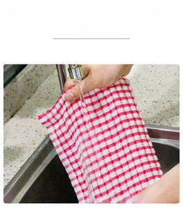 Detail of red checkered cotton dish towel being rinsed in sink to show easy cleaning