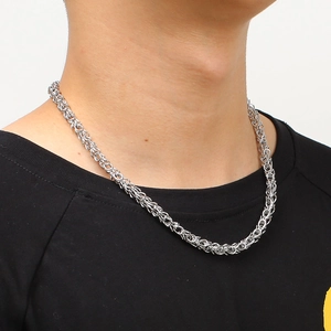 Minimalist silver stainless steel crown necklace with braided chain on male model