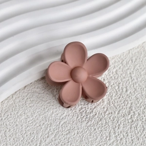 Detail shot of matte flower hair claw clip in soft rose pink with smooth matte texture