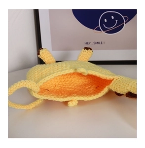 Detail view of the hand-knitted yellow giraffe shoulder bag with interior storage space