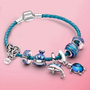 Blue woven leather bracelet with silver whale, dolphin, and sea turtle charms