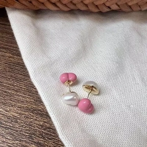Detailed view of candy color heart studs with pink glaze and creamy white pearl texture