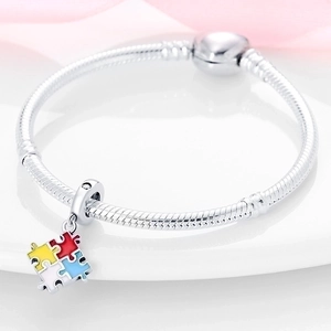 Silver snake chain bracelet featuring a colorful four-piece puzzle enamel charm pendant