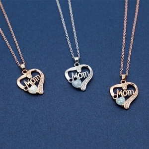 Rose gold and silver Mom heart necklace with opal and zircon on blue background