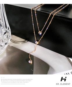 Dettaglio della collana multistrato in titanio oro rosa con tre ciondoli di cristallo