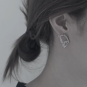 Minimalist silver butterfly wing stud earring in hollow design worn by female model