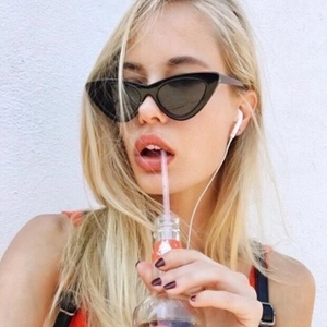 Classic black cat-eye sunglasses with a stylish small frame, worn by a model in natural light