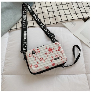 Detail of white mini suitcase bag with red roses and Forever Young wide strap