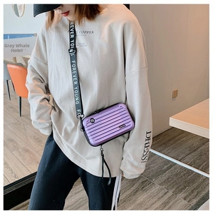 Detail view of purple mini suitcase crossbody bag with Forever Young strap and striped texture