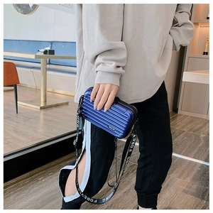 Detail view of mini suitcase crossbody bag in navy blue with Forever Young strap