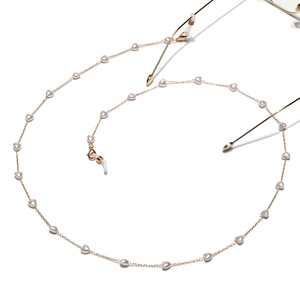 Détail de chaîne à lunettes dorée avec perles en cœur et boucles antidérapantes