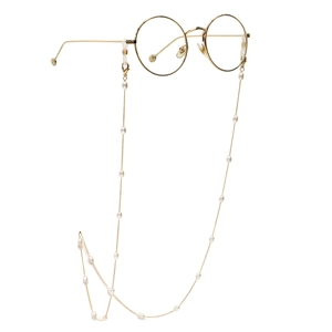 Chaîne de lunettes dorée élégante avec perles blanches sur monture ronde, fond blanc