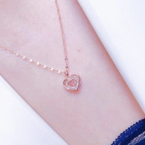 Rose gold heart pendant necklace with shimmering crystals on a dainty chain for women