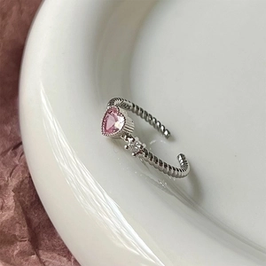 Macro detail of S925 sterling silver twisted ring band with pink heart-shaped gemstone