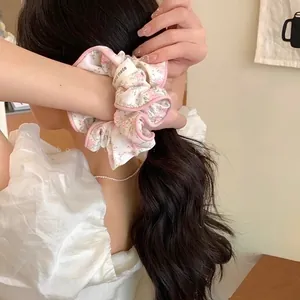Detail of floral scrunchie with hand made label on low ponytail hairstyle