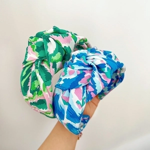 Close-up of wide knotted headbands with colorful abstract camouflage printed fabric