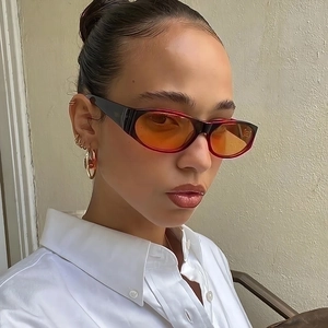 Retro oval sunglasses with black frames and yellow lenses worn by a model in profile