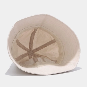 Inside detail of beige cotton bucket hat showing quality stitching and reinforcement bands