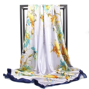 Detail van de zijden sjaal met narcisbloemenprint, donkerblauwe randen en satijn
