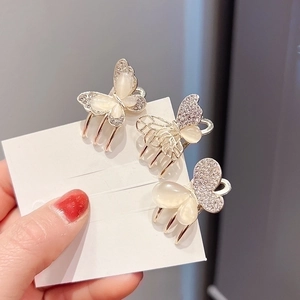 Three gold butterfly hair clips with cat eye stone and rhinestones on a white card
