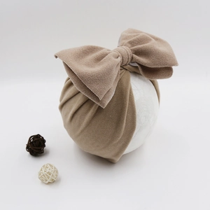 Detailed texture of baby turban hat with a large bow on a soft cashmere-like fabric