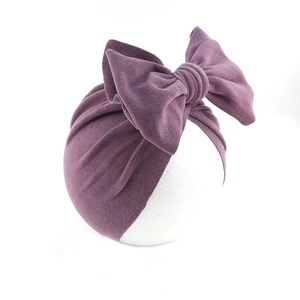 Detailed view of purple velvet baby turban hat with a large decorative soft bow
