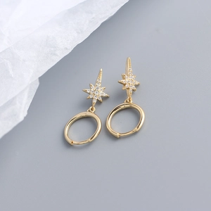 Detailed macro view of golden S925 silver star earrings with pavé cubic zirconia