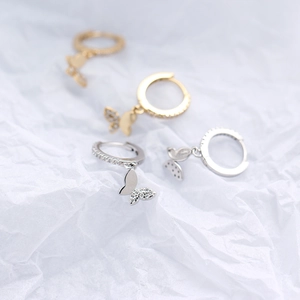 Detailed view of silver and gold butterfly hoop earrings with sparkling crystal accents